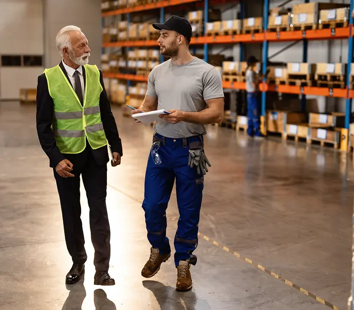 Dos hombres trabajando y platicando en el almacén